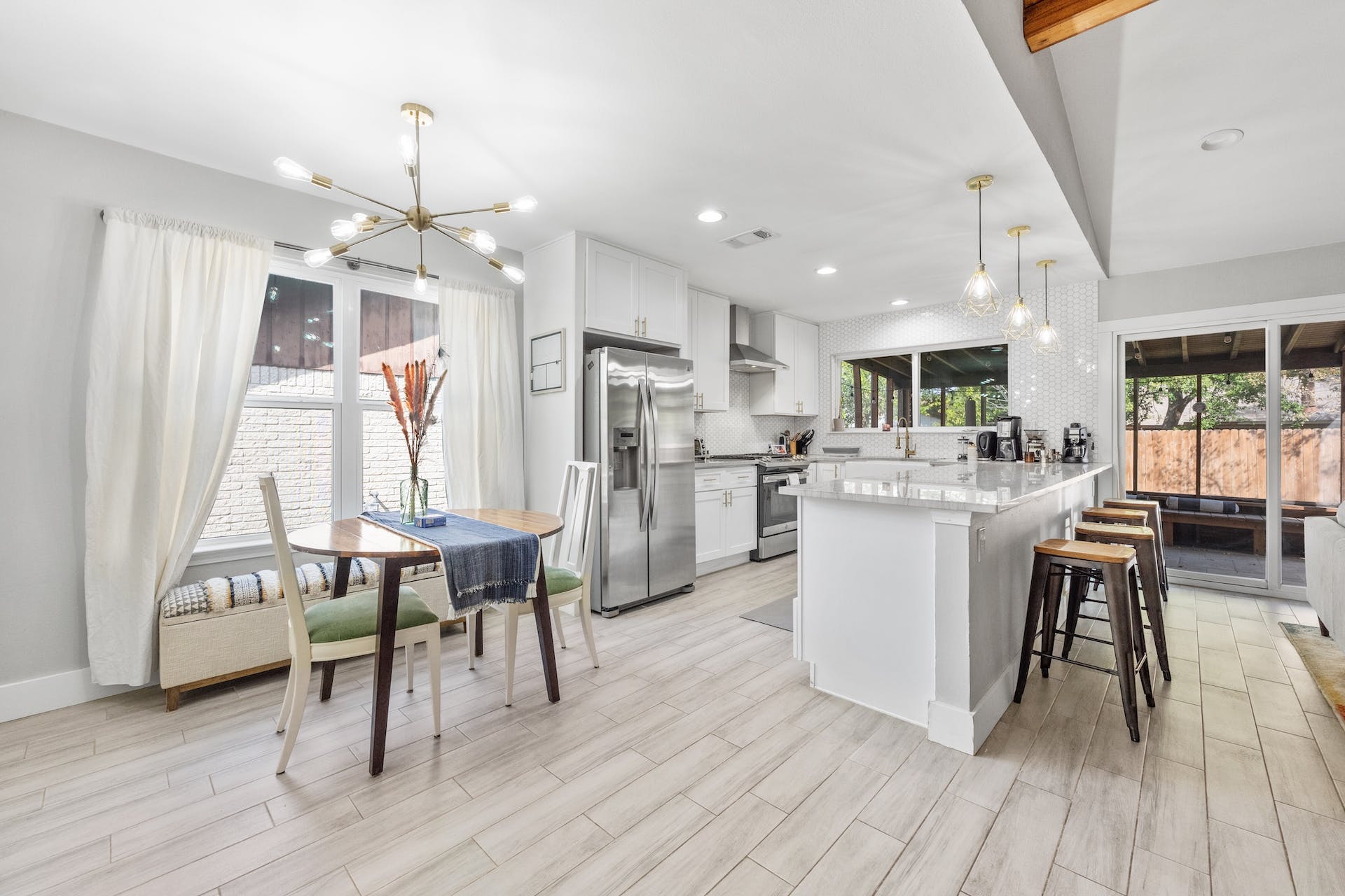 1400 Chippeway Lane Austin, TX 78745 - Photo 8 of 24 Kitchen featuring white cabinets, stainless steel appliances, suspended lighting, a breakfast bar, and a peninsula