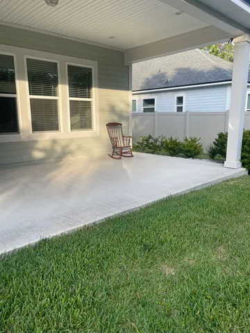 a front view of house with yard and trees in the background