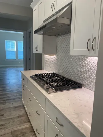 a stove top oven sitting inside of a kitchen