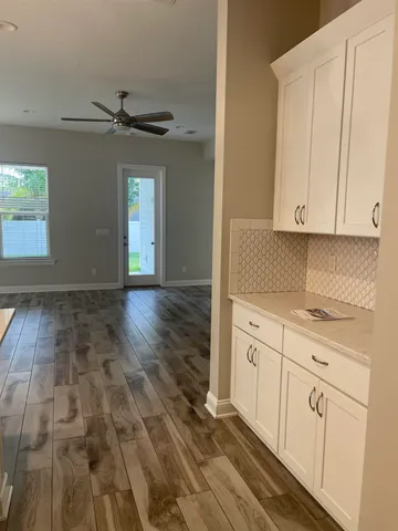 a kitchen with granite countertop white cabinets and white appliances