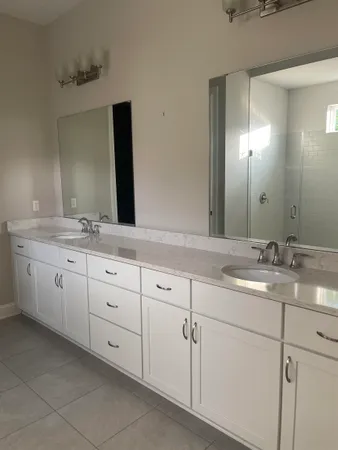 a bathroom with a granite countertop sink double and mirror