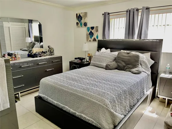 a bedroom with a large bed and wooden floor