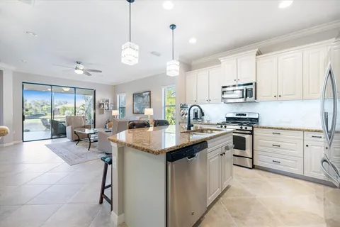 a kitchen with kitchen island granite countertop a stove cabinets and refrigerator