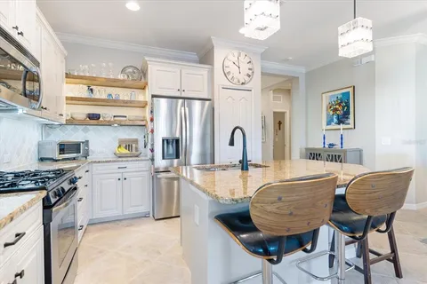 a living room with furniture a large window and chandelier