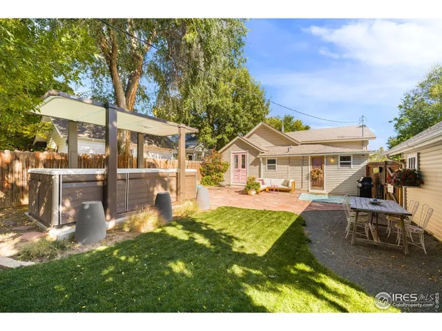 a backyard of a house with barbeque oven table and chairs