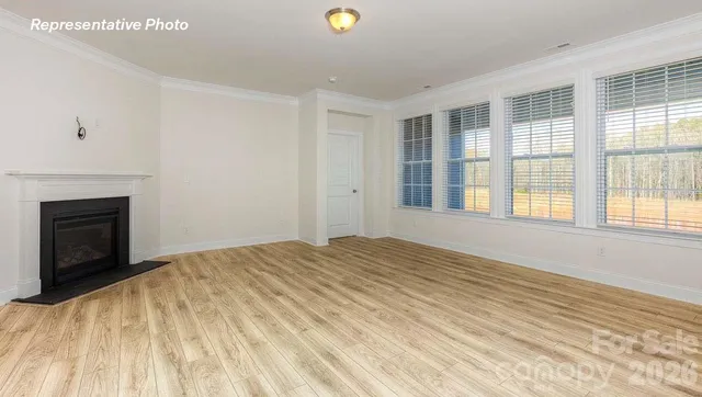 a view of an empty room with a window and a fireplace