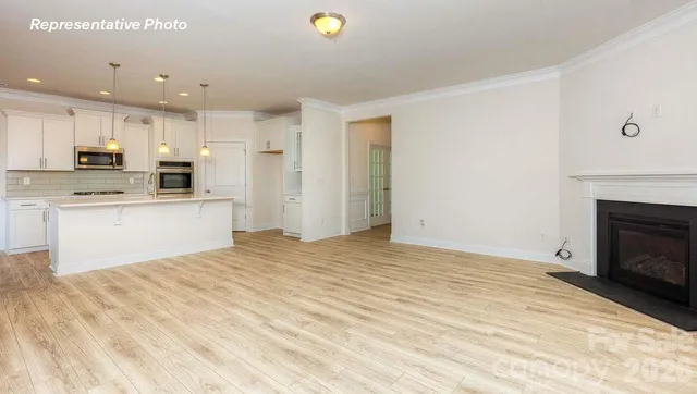 a kitchen with a refrigerator a stove top oven a sink and white cabinets