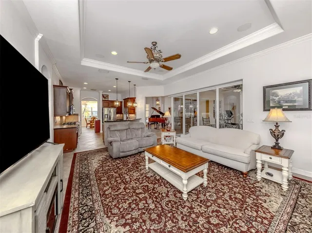 a living room with furniture a flat screen tv and a large window