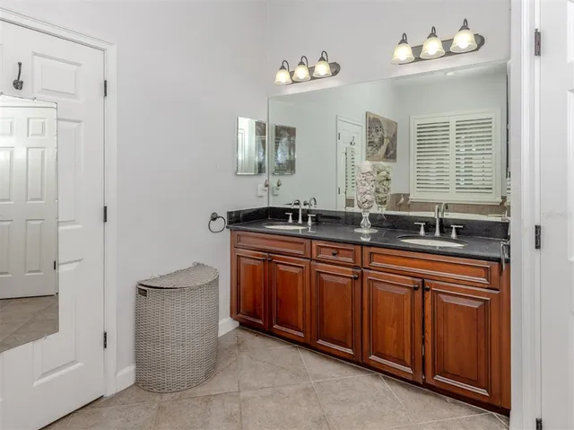 a bathroom with a granite countertop sink mirror vanity and toilet