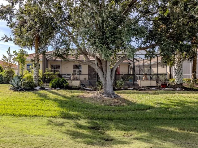 a front view of a house with a garden and trees