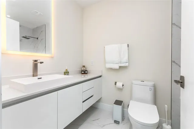 a bathroom with a toilet a sink and mirror