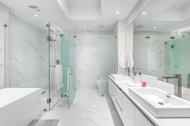 a bathroom with a double vanity sink mirror double and bathtub