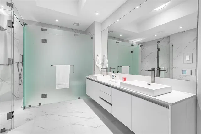 a bathroom with a double vanity sink mirror and shower