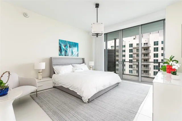 a bedroom with a large bed and a chandelier