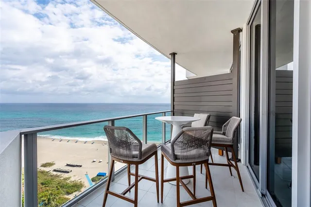 a balcony view with two chairs and a table