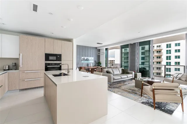 a living room with furniture a large window and a dining table