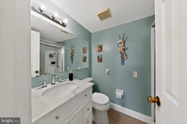 a bathroom with a sink and mirror with toilet