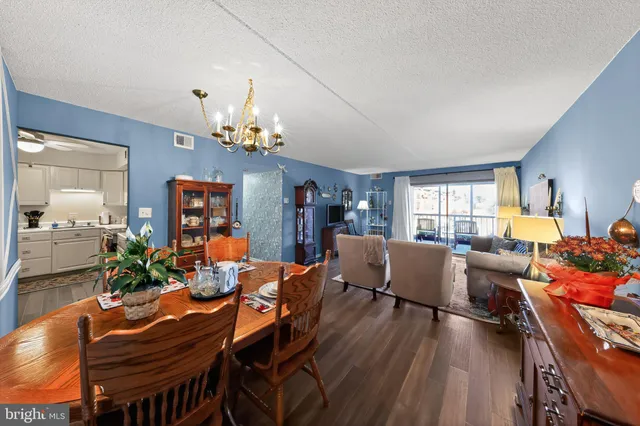 a view of a dining room with furniture a chandelier and wooden floor