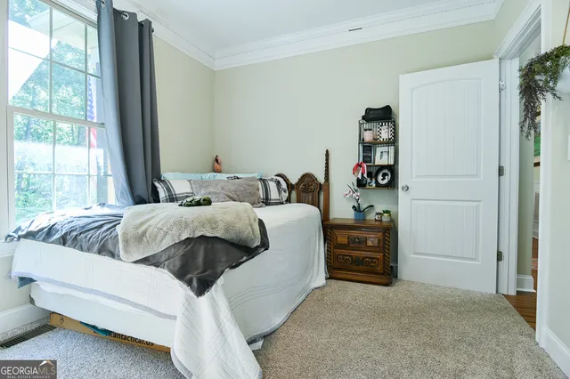 a bedroom with a bed and a large window