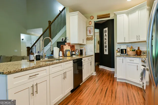 a kitchen with granite countertop white cabinets and white appliances