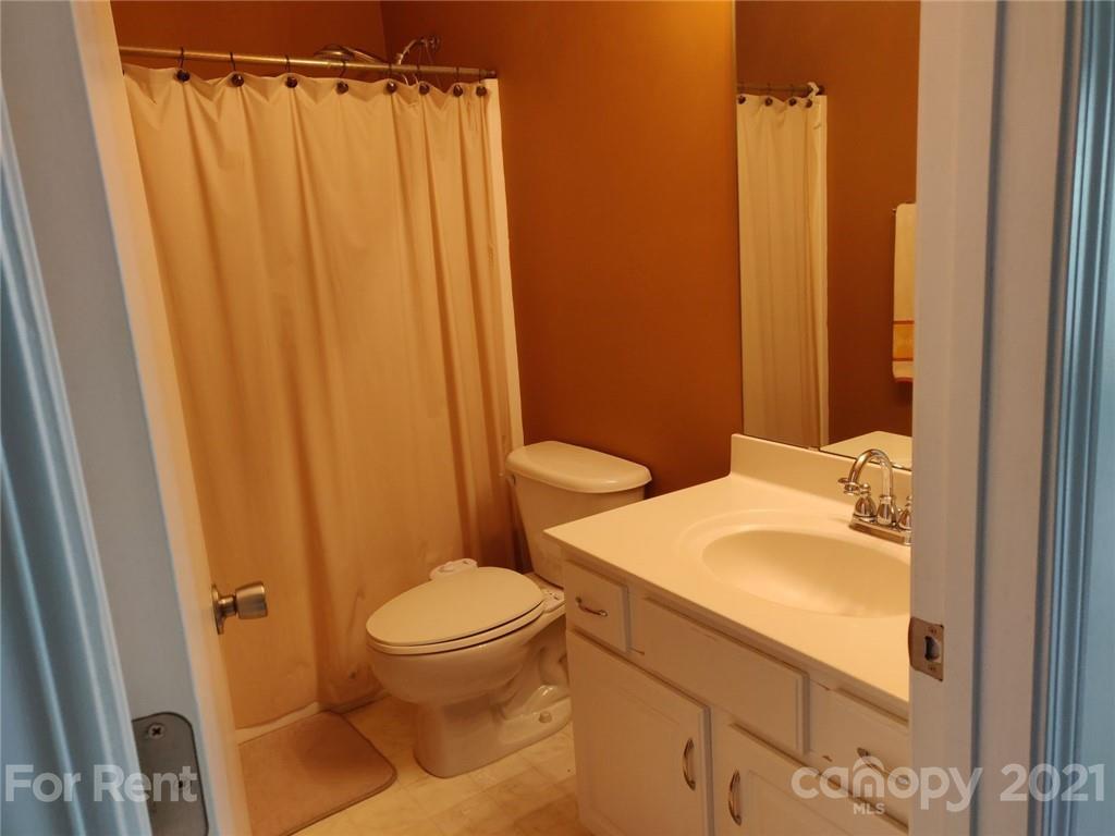 3509 Summerfield Ridge Lane, Unit 33 Matthews, NC 28105 - Photo 11 of 13 a bathroom with a sink a toilet and shower curtain