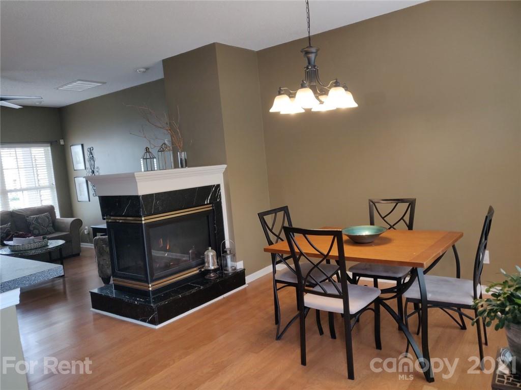 3509 Summerfield Ridge Lane, Unit 33 Matthews, NC 28105 - Photo 3 of 13 a living room with furniture a fireplace and a chandelier