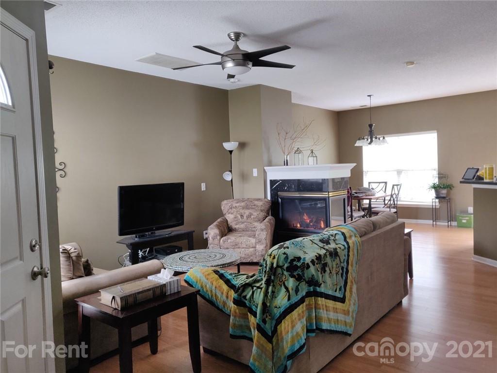 3509 Summerfield Ridge Lane, Unit 33 Matthews, NC 28105 - Photo 5 of 13 a living room with furniture a flat screen tv and a fireplace