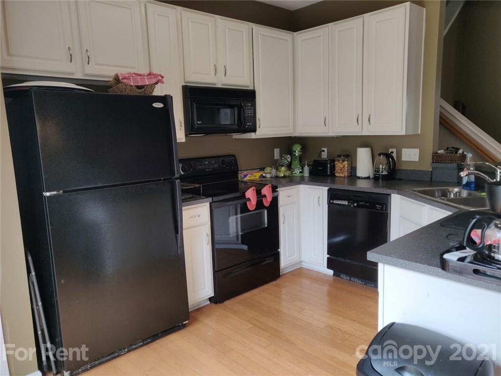 3509 Summerfield Ridge Lane, Unit 33 Matthews, NC 28105 - Photo 7 of 13 a kitchen with a refrigerator and a stove top oven