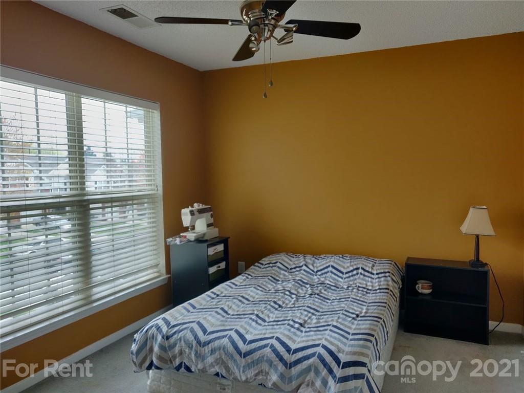 3509 Summerfield Ridge Lane, Unit 33 Matthews, NC 28105 - Photo 10 of 13 a bedroom with a bed and a lamp