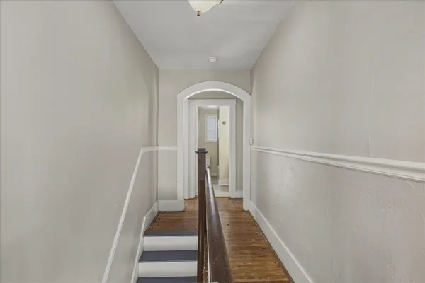 a view of a hallway with wooden floor and stairs