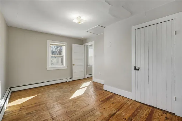 a view of empty room with wooden floor
