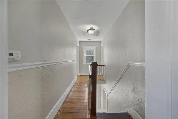 an empty room with wooden floor and closet area
