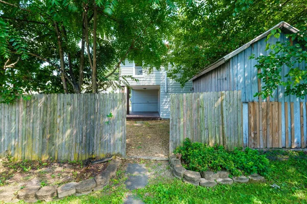 a view of a house with a big yard and a large tree
