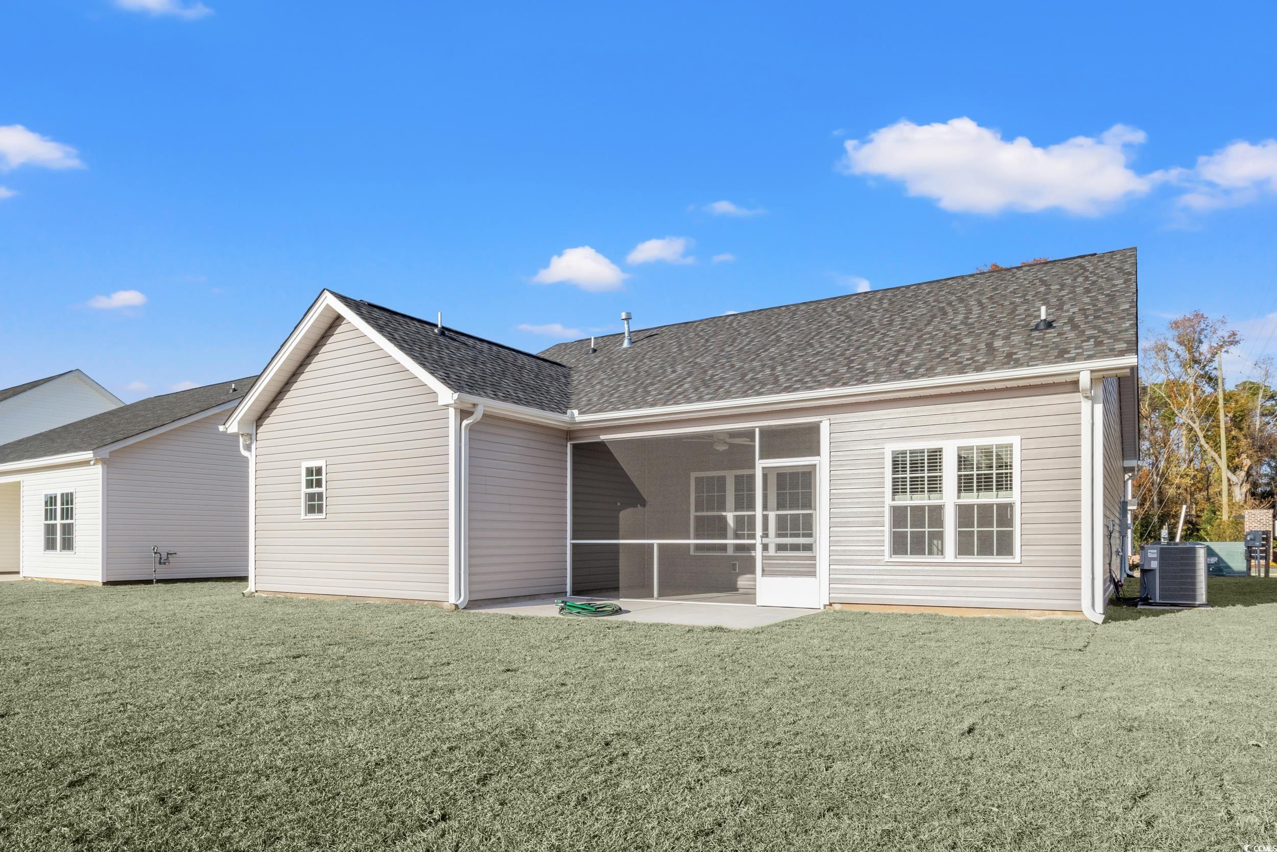 109 Lakota Loop Longs, SC 29568 - Photo 20 of 20 Rear view of house featuring a lawn, central air c