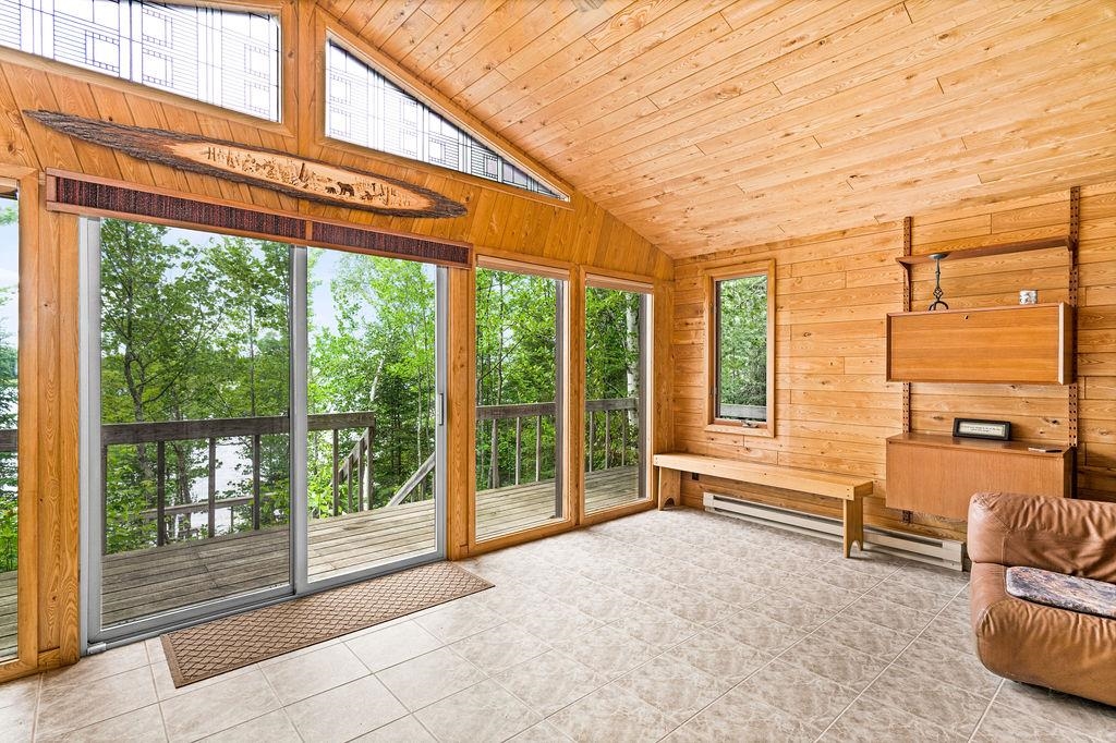 8639 South Strand Lake Road Cotton, MN 55724 - Photo 15 of 50 Gas Fireplace, Sliding Glass door to the lake, Floor to Ceiling Windows, Vaulted T&G ceiling, Stain glass