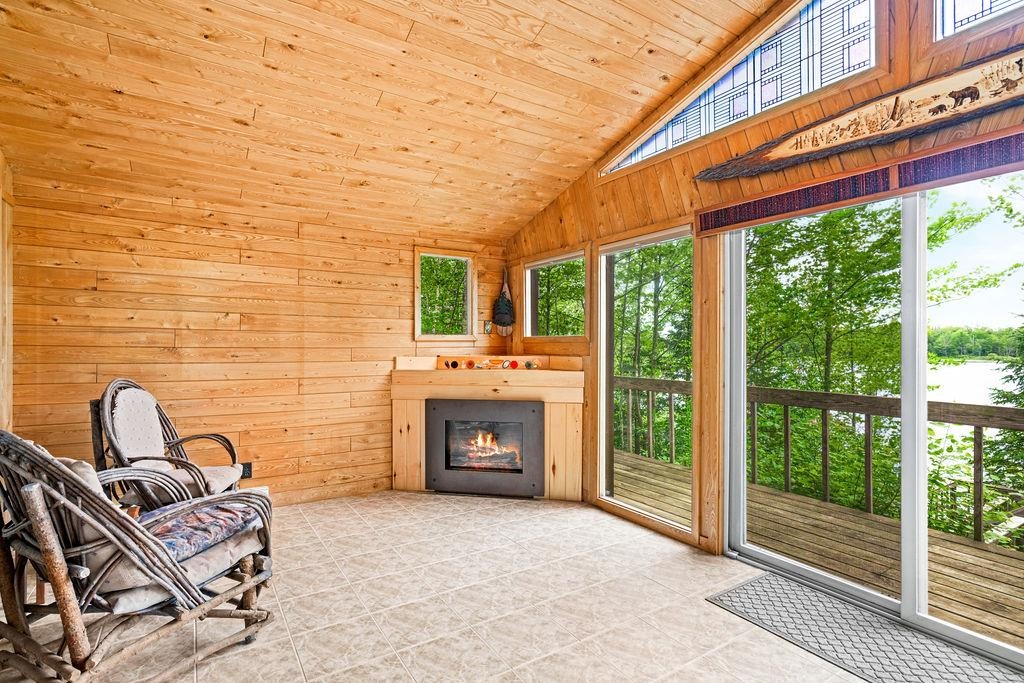 8639 South Strand Lake Road Cotton, MN 55724 - Photo 4 of 50 Tiled floors, Gas fireplace, floor to ceiling window and sliding glass door to the multi level deck