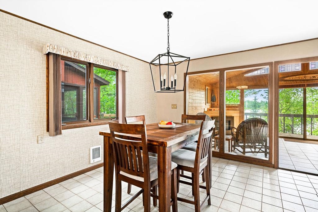 8639 South Strand Lake Road Cotton, MN 55724 - Photo 10 of 50 Tiled dining room featuring a notable chandelier and a wealth of natural light