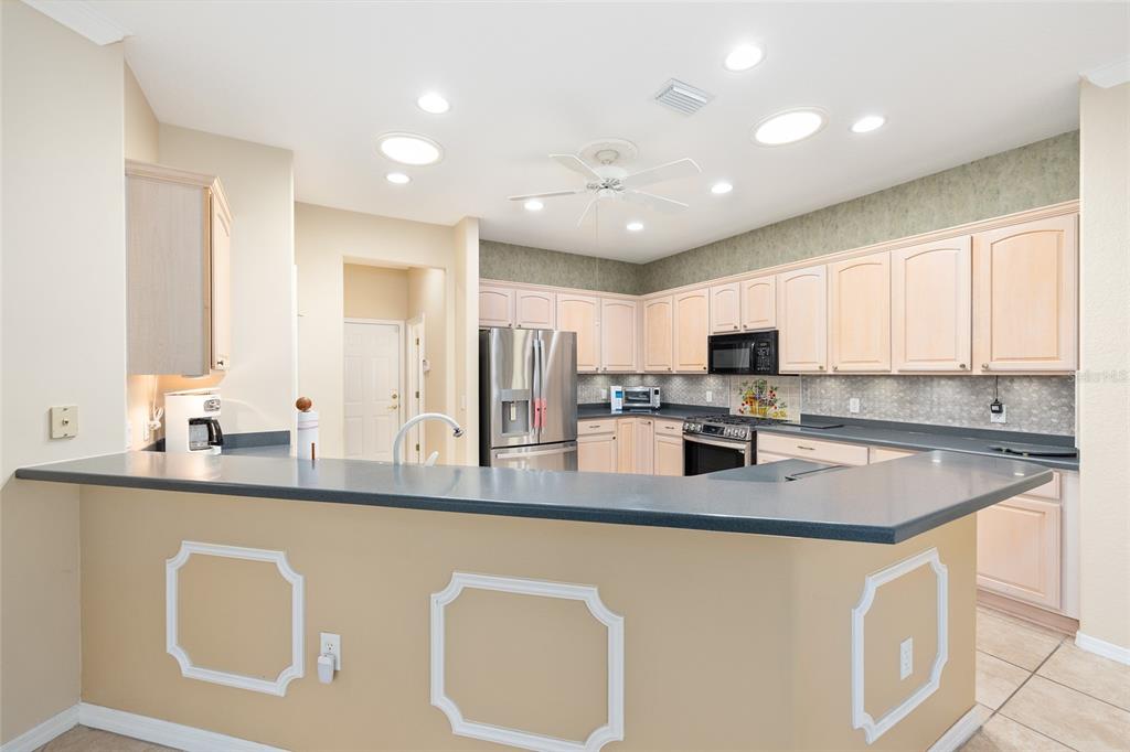 9019 Southeast 120th Loop Summerfield, FL 34491 - Photo 11 of 69 a kitchen with stainless steel appliances granite countertop a sink a stove a refrigerator a center island and cabinets