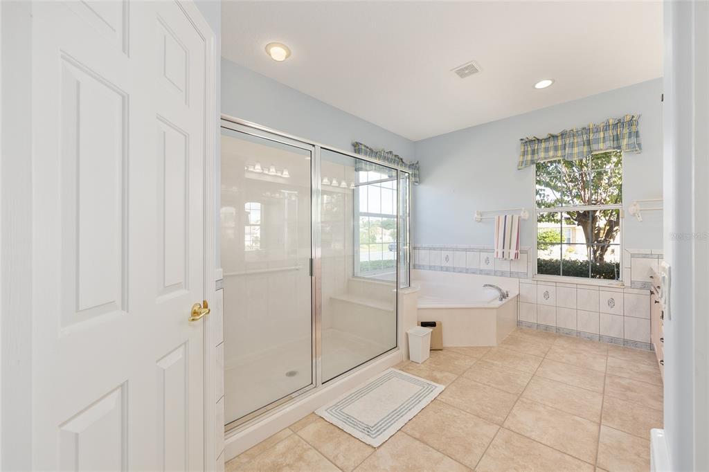 9019 Southeast 120th Loop Summerfield, FL 34491 - Photo 19 of 69 a bathroom with a glass shower door and a bathtub