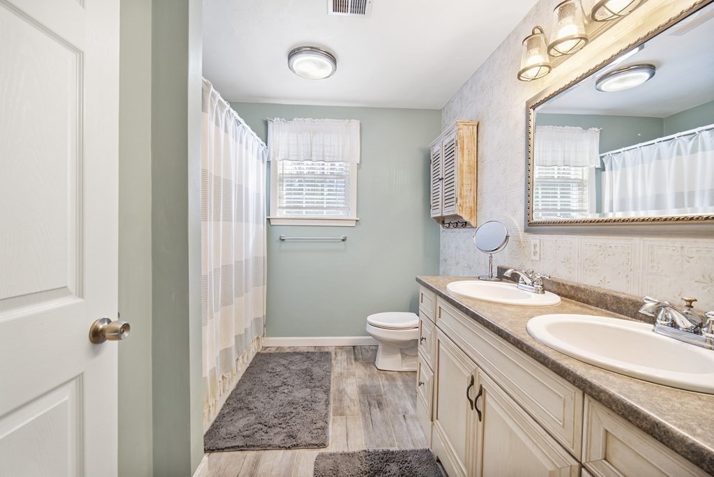 390 Cooper Road Northbridge, MA 01534 - Photo 26 of 34 a bathroom with a sink a toilet a mirror a vanity a window and shower