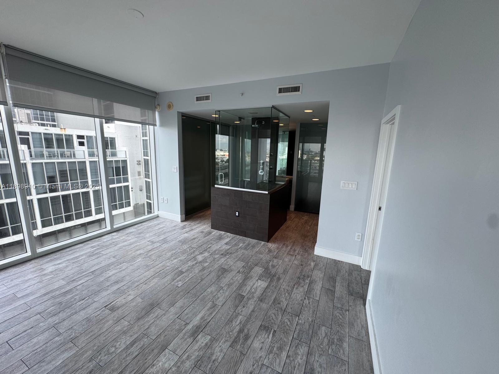1040 Biscayne Boulevard, Unit 1106 Miami, FL 33132 - Photo 13 of 29 a view of a big room with wooden floor and windows