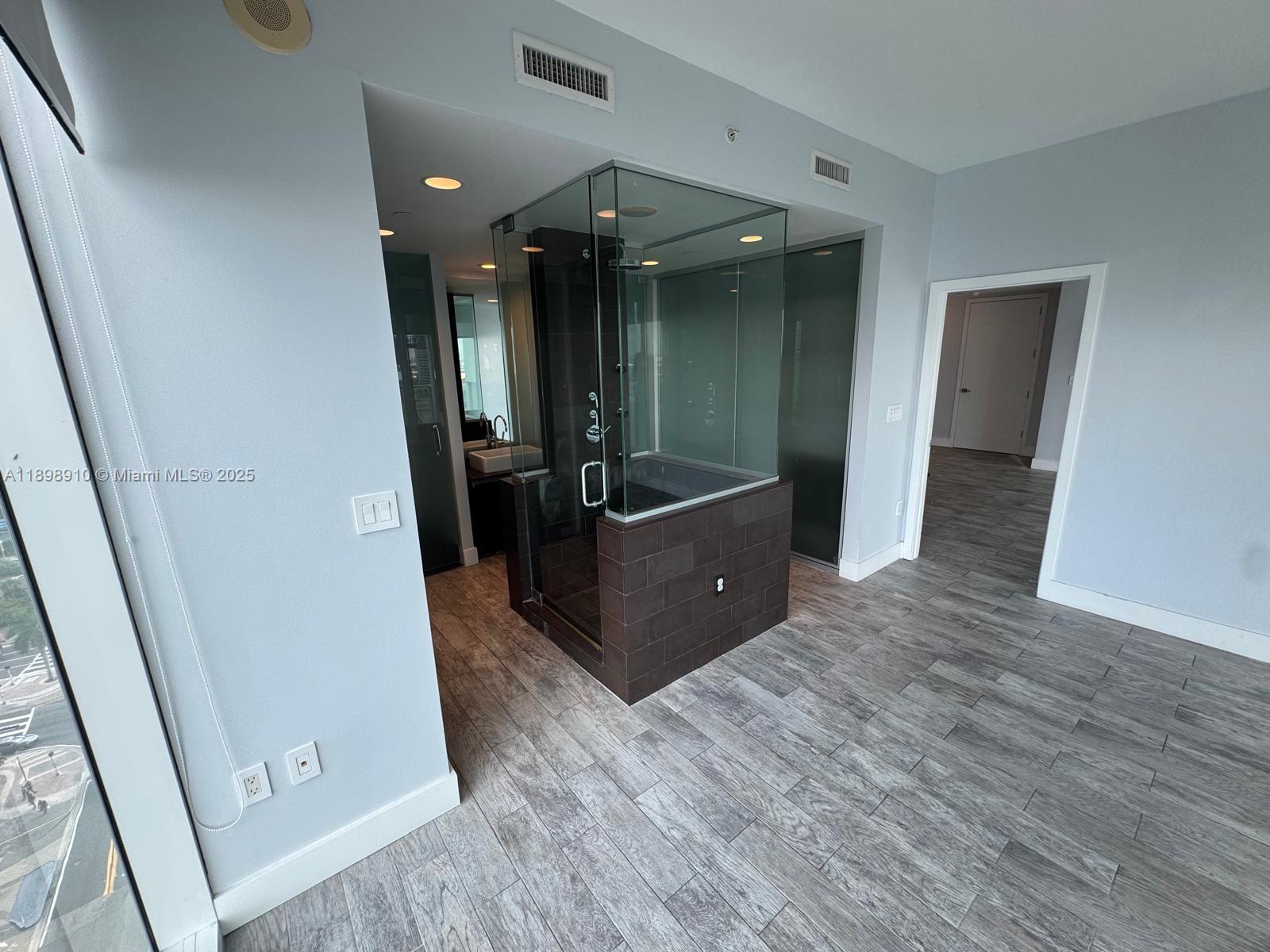 1040 Biscayne Boulevard, Unit 1106 Miami, FL 33132 - Photo 14 of 29 wooden floor in an empty room with a mirror