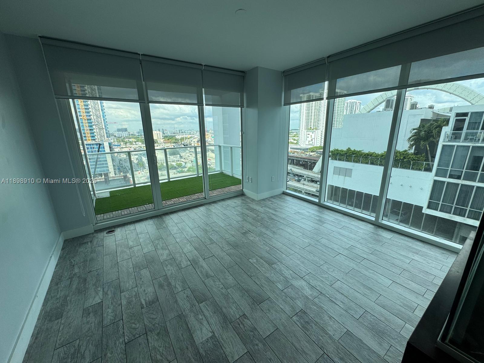 1040 Biscayne Boulevard, Unit 1106 Miami, FL 33132 - Photo 21 of 29 a view of an empty room with wooden floor and a window