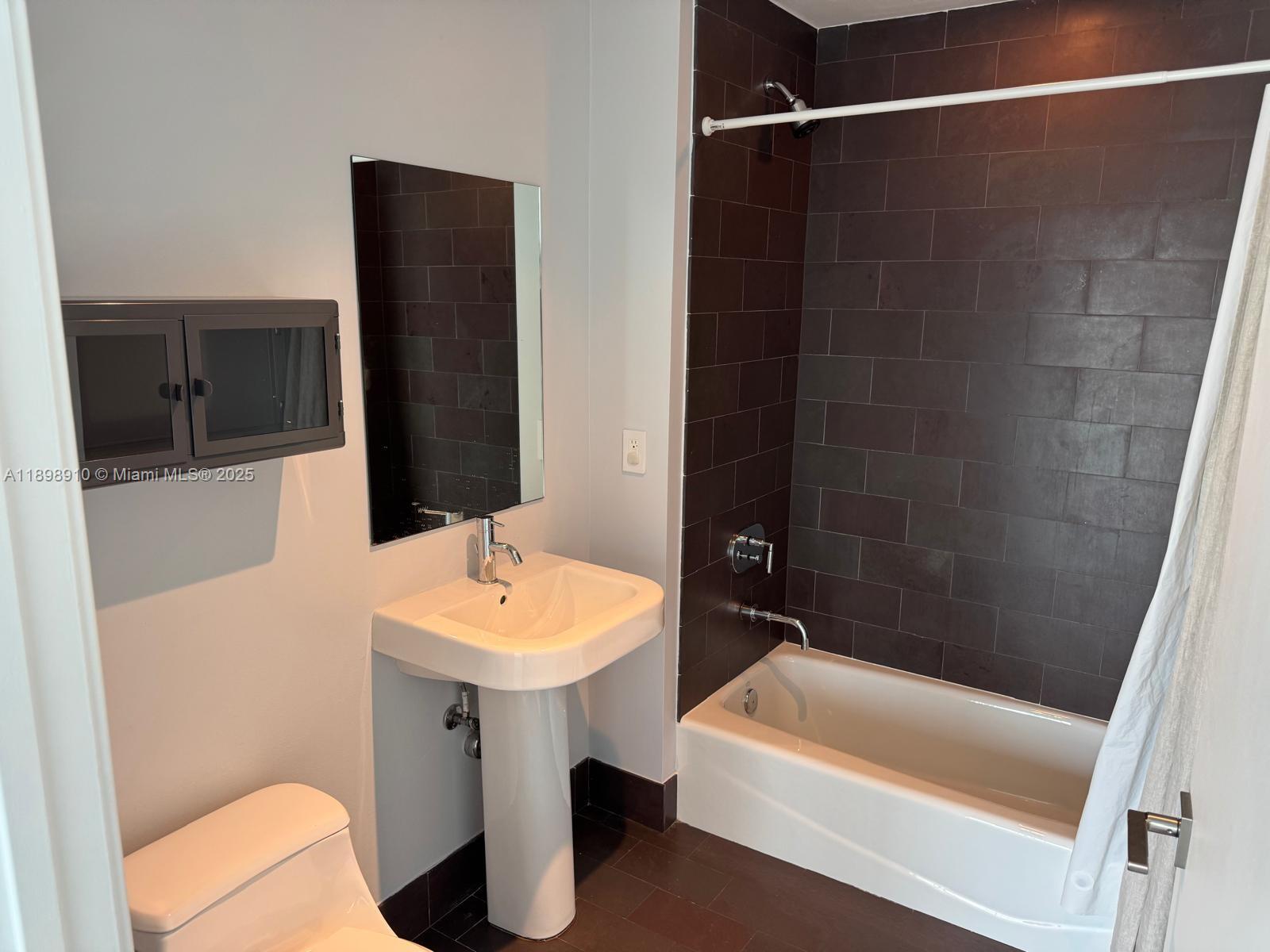 1040 Biscayne Boulevard, Unit 1106 Miami, FL 33132 - Photo 23 of 29 a bathroom with a sink a toilet and shower