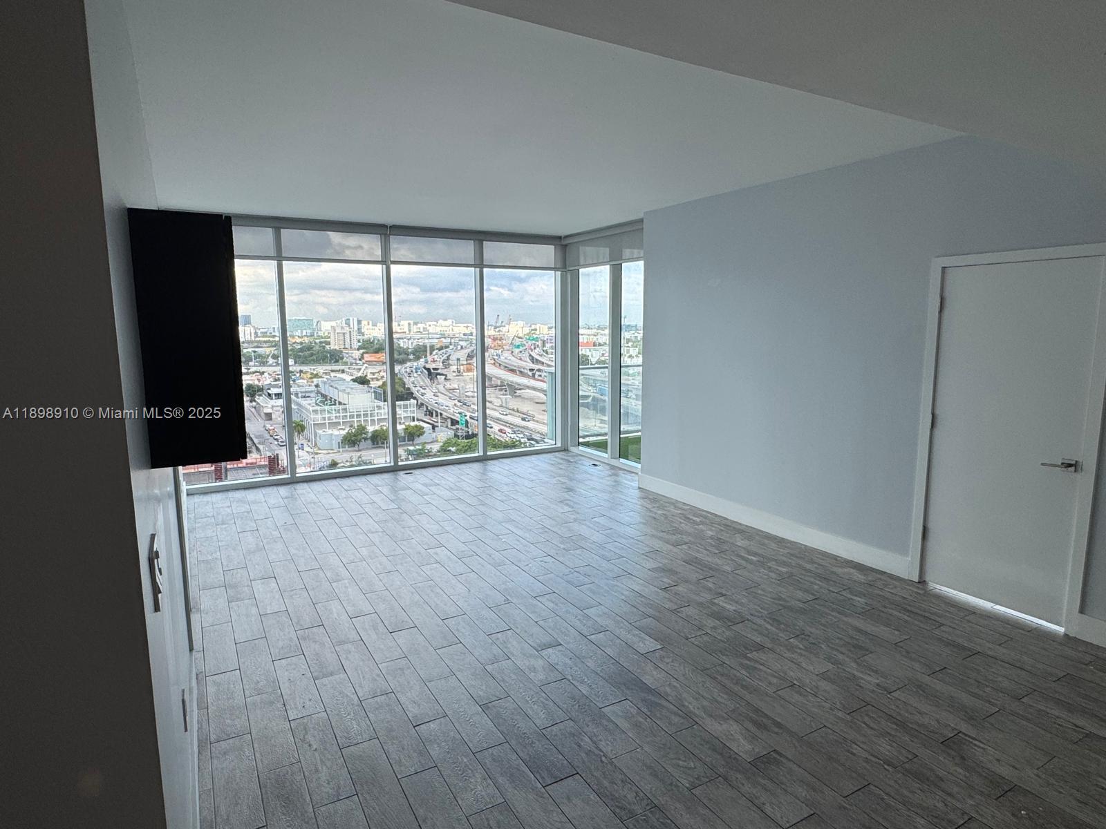 1040 Biscayne Boulevard, Unit 1106 Miami, FL 33132 - Photo 9 of 29 wooden floor in an empty room with a window
