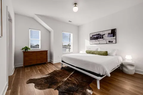 a bedroom with a bed and wooden floor