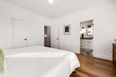 a bedroom with a bed and wooden floor