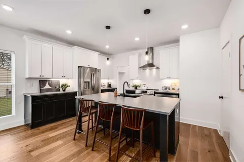 a kitchen with kitchen island wooden cabinets and stainless steel appliances
