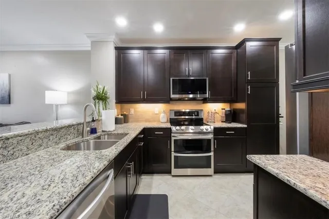 a kitchen with stainless steel appliances granite countertop a sink stove and refrigerator