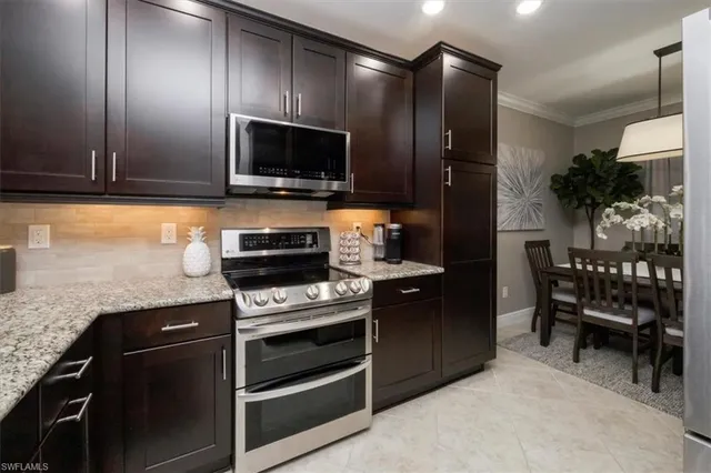 a kitchen with stainless steel appliances kitchen island granite countertop a stove and a microwave